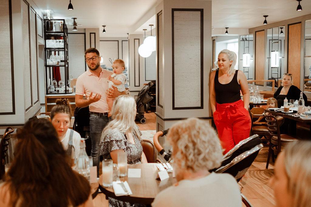 Liam holding Eva speaking to families